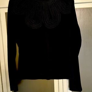 Black silky blouse with stitching details.